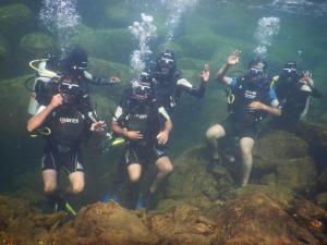 un grupo de personas de pie en el agua en Hotel Sea Fans, en Ratnagiri