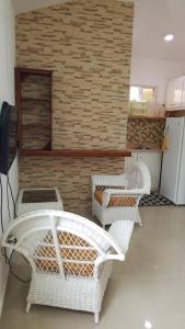 Habitación con 4 sillas de mimbre y pared de ladrillo en Fully Equipped 1br Studio –dt–2mins To The Beach, en Sosúa