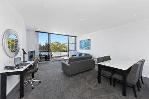 a living room filled with furniture and a large window at Mantra Quayside Port Macquarie in Port Macquarie