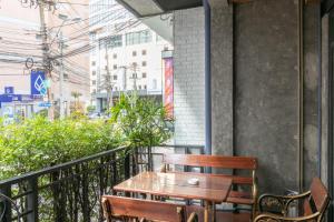 a wooden table and chairs on a balcony at Zleepmotion Bangkok in Bangkok