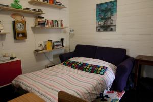 a small room with a bed with a blanket at Piccolo in Leura