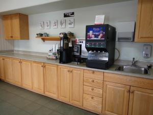 - un comptoir de cuisine avec un four micro-ondes et un évier dans l'établissement Super 8 by Wyndham Swan River MB, à Swan River