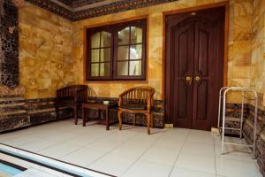 a room with two chairs and a door at Segara Sadhu Inn Kuta by ecommerceloka in Kuta +73 photos