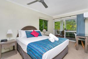 una camera da letto con un letto grande e un balcone di Seascape Holidays at The Queenslander a Port Douglas Altre 45 foto