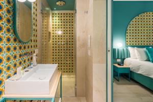 a bathroom with a tub, sink and shower at Maison De Trazegnies Marina Di Ragusa in Marina di Ragusa