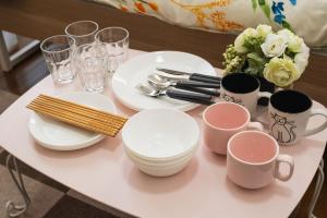 a table topped with plates and cups and utensils at ROOMs六本松 06 in Fukuoka