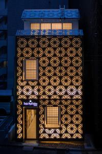 un edificio con un design geometrico sul lato di esso di Shinjuku Miyabi Residence a Tokyo