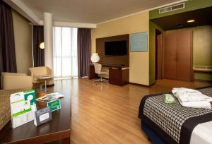 a hotel room with a bed and a desk at Holiday Inn Turin Corso Francia by IHG in Turin