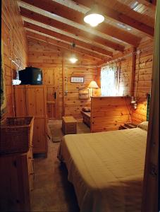 a bedroom with a bed in a wooden cabin at Cabañas Mas de Borràs in Villahermosa del Río