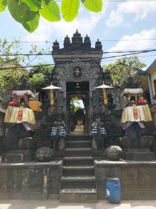 um edifício de pedra com escadas que levam a uma porta em Eka's Homestay em Ubud