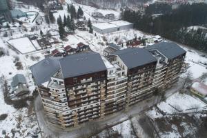 uma vista aérea de um edifício na neve em Green FOREST Resort Colina Marei em Sinaia