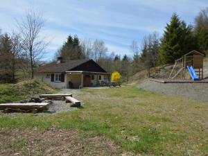 een huis met een picknicktafel en een speeltuin bij Holiday home in the middle of nature with sauna in Longfaye