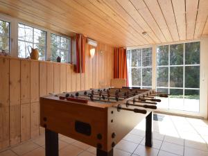 a large wooden room with a large foosball table at Holiday home in the middle of nature with sauna in Longfaye