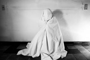 eine Person in einem weißen Kleid, die an eine Wand lehnt in der Unterkunft SPIRIT of the MOON in Brescia