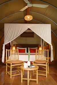 duas cadeiras e uma cama num quarto em Templation Hotel em Siem Reap