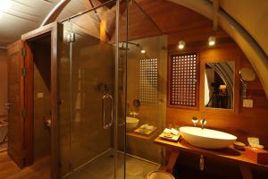 uma casa de banho com uma cabina de duche em vidro e um lavatório. em Templation Hotel em Siem Reap