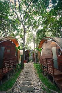 a walkway through a group of tents with benches at Templation Hotel in Siem Reap