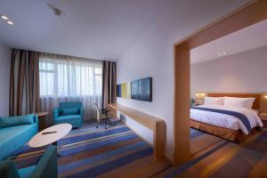 Habitación de hotel con cama y sofá en Holiday Inn Express Shanghai Zhenping, an IHG Hotel en Shanghái