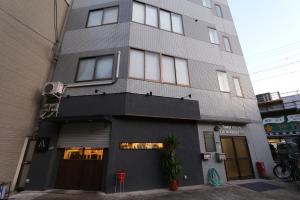 a tall building with windows on the side of it at Liz2 Guest House Liz Nakazakicho in Osaka