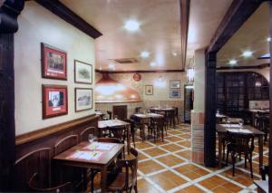 restauracja ze stołami i krzesłami w pokoju w obiekcie Hostal El Jardín w mieście Benidorm