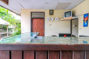 a glass counter in front of a room with a door at OYO 1654 Maha Bharata Kuta Inn in Legian