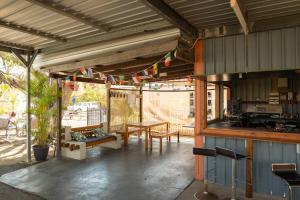 eine Terrasse mit einem Tisch und eine Küche mit Flaggen in der Unterkunft Rockhampton Backpackers YHA in Rockhampton