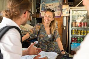 a woman sitting at a cash register in a store at Rockhampton Backpackers YHA in Rockhampton
