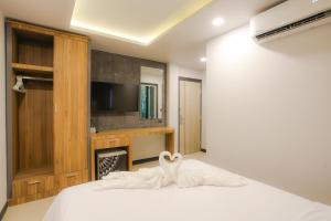 a bedroom with a bed with a swan on it at The Mantra Hotel Kata Noi in Kata Beach