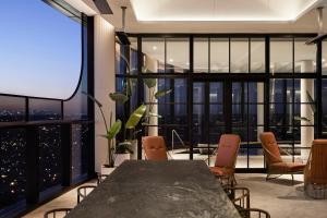 a room with a table and chairs and a large window at Hotel Chadstone Melbourne MGallery Collection in Chadstone