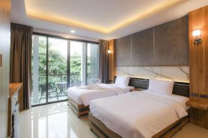 two beds in a hotel room with a balcony at The Mantra Hotel Kata Noi in Kata Beach +36 photos