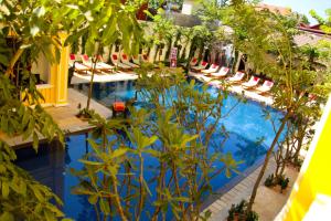 a pool with chairs and trees in front of a building at La Residence WatBo Hotel in Siem Reap