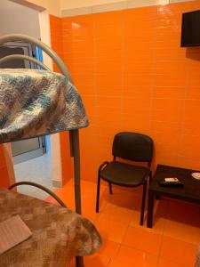 a chair and a table in a room with orange walls at Villa belvedere in Pontecagnano