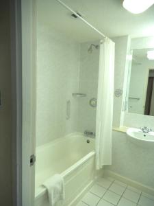a bathroom with a shower, sink, and mirror at Airport Inn Gatwick in Horley