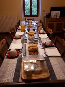 długi stół z długim stołem z jedzeniem w obiekcie Chez Nathalie Et Jean Claude w mieście Saint-Marc-à-Frongier