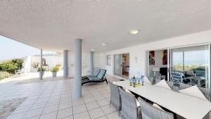 a living room with a table and chairs on a balcony at On The Beach Apartments in Yzerfontein