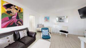 a living room with a couch and a painting on the wall at On The Beach Apartments in Yzerfontein