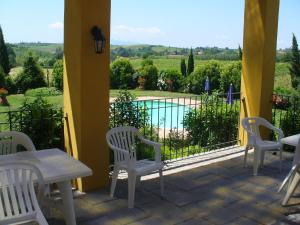 a patio with chairs and a view of a pool at Farmhouse in Vinci with Swimming Pool Terrace Garden BBQ in Vinci