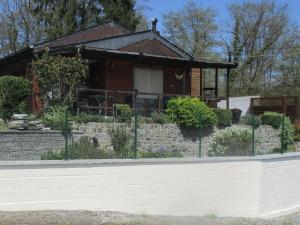 a brick house with a fence in front of it at Comfortable chalet in Petit Han with garden and barbecue in Durbuy