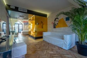 ein Wohnzimmer mit einer weißen Couch und einer Topfpflanze in der Unterkunft Platforma Design Hotel in Tbilisi City