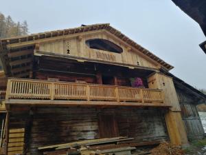 インナーヴィルグラーテンにあるAlmhütte Senfterの木造の家屋で、バルコニーが付いています。