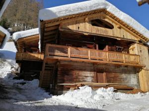 a log cabin with snow on the side of it at Almhütte Senfter in Innervillgraten