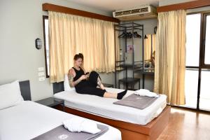 a woman sitting on a bed in a bedroom at Mad Monkey Bangkok in Bangkok