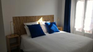 Un dormitorio con una cama con almohadas azules y una ventana en Charmant 2 pièces Coeur de Cannes PA8, en Cannes