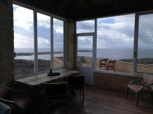 a room with large windows and a table and chairs at Elafonisi Villa above the Beach in Elafonisi
