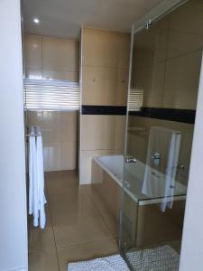 a bathroom with a glass shower and a sink at Accommodation Front - Gorgeous 4 Sleeper Beachfront Apartment in Durban +17 photos