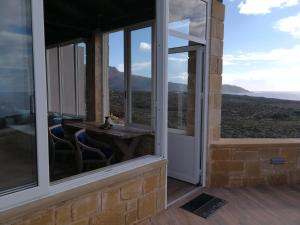 a room with windows and a table with a view at Elafonisi Villa above the Beach in Elafonisi