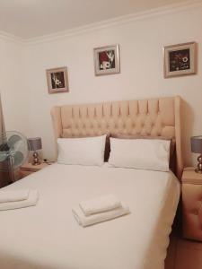 a large white bed with two white towels on it at 40 La Mer, Illovo Beach Apartment in Amanzimtoti