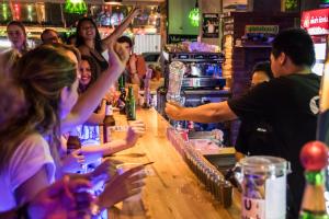 a group of people sitting at a bar at Mad Monkey Bangkok in Bangkok
