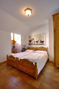 a bedroom with a large wooden bed in a room at Albergo Alle Alpi in Comeglians