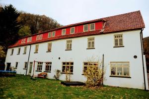 une grande maison blanche avec un toit rouge dans l'établissement John stube, à Rinteln